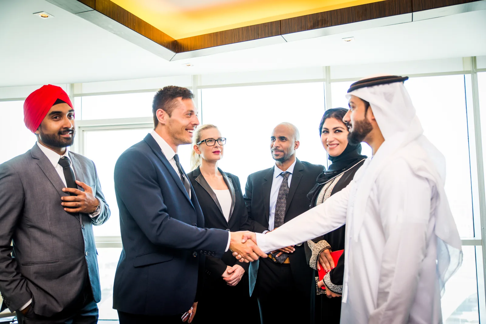 Business professionals shaking hands in a Dubai office